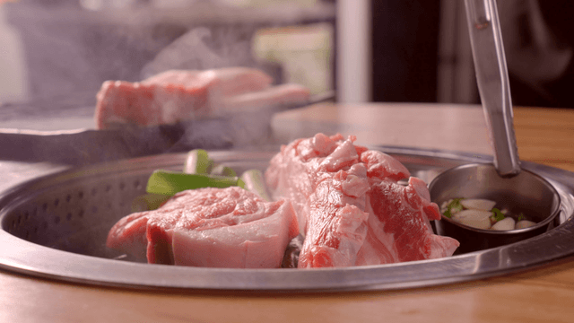 Grilling pork belly on a Korean barbecue grill