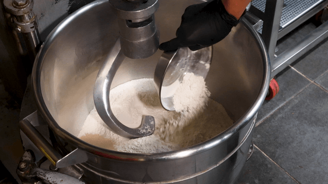 Flour being added to a large mixer
