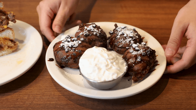 Chocolate dessert beside burger on wooden table