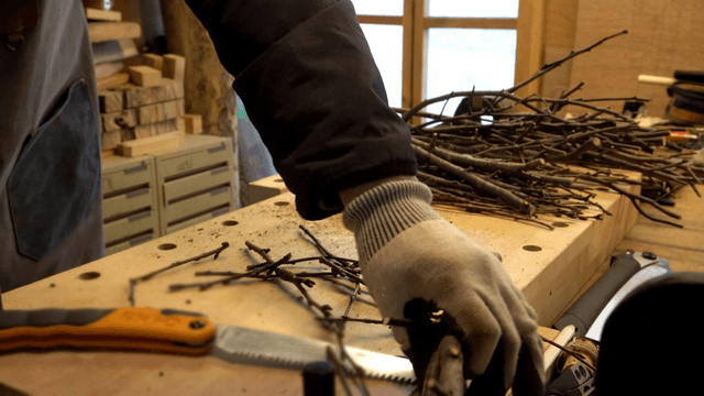 Craftsman trimming branches on workbench