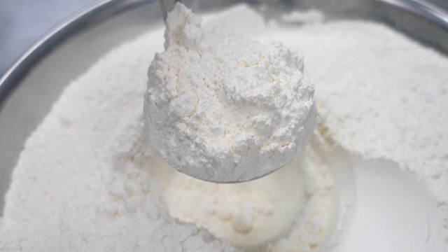 Flour being scooped from a bowl