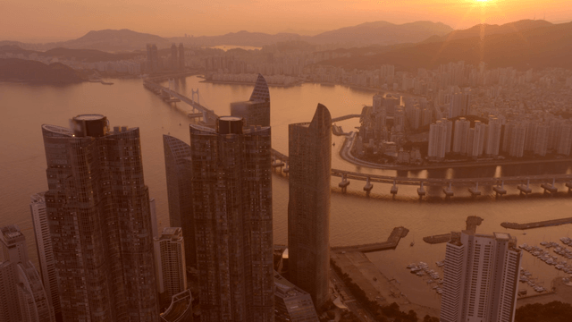 Sunset over a coastal city with high-rise buildings