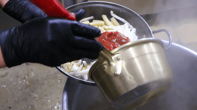 떡볶이 재료가 든 냄비에 육수를 넣는 장면