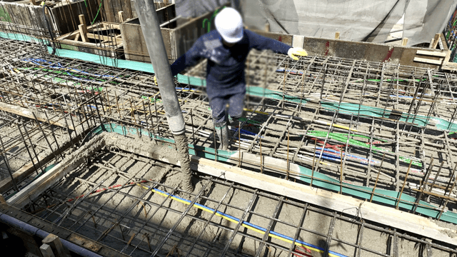 Worker pouring concrete at construction site