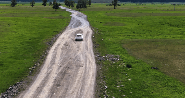 A car driving on a rural dirt road