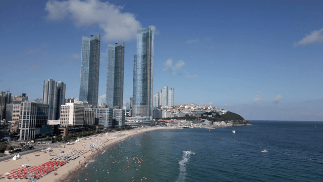 Bustling beach with towering skyscrapers