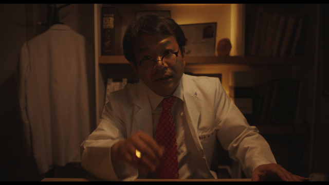 Doctor explaining while lowering glasses in dark office