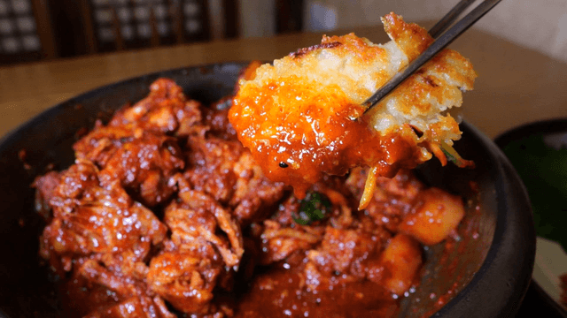 Potato pancake dipped in spicy braised chicken