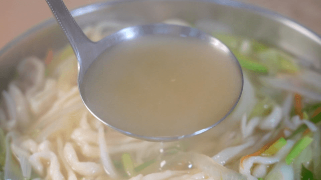 Rich broth of handmade noodle soup with vegetables
