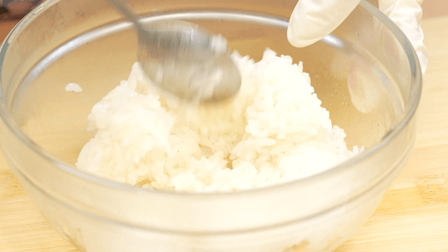 Rice mixed in a glass bowl with a spoon