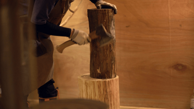 Person chopping wood indoors
