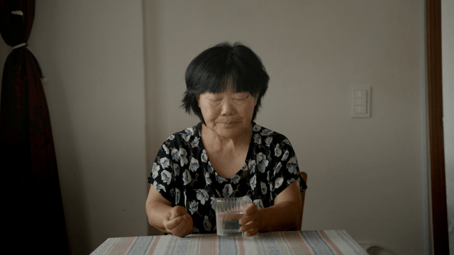 An elderly woman taking medicine