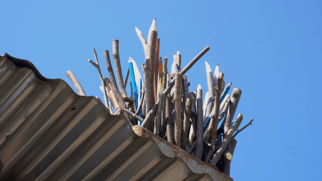 Wooden pencil sculpture placed on a roof