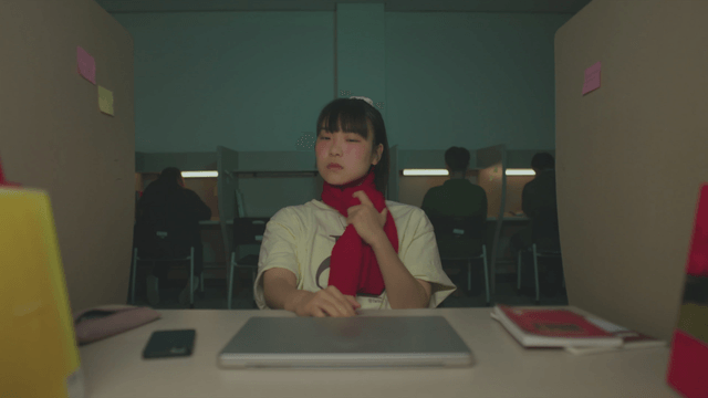 Female student wearing a red scarf and feeling hot in the reading room
