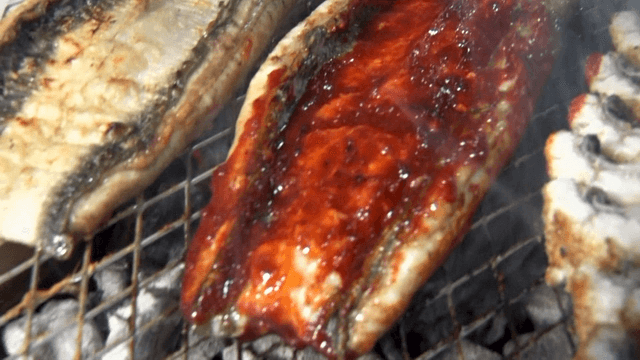 Grilled eels coated with spicy sauce over charcoal fire