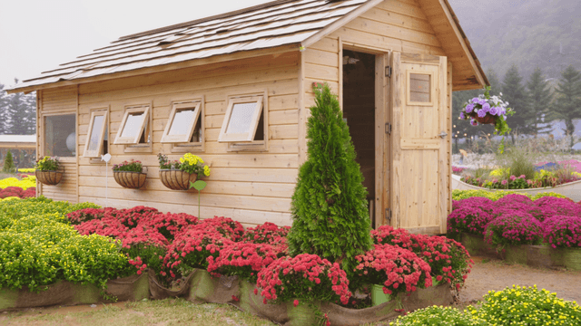 다채로운 꽃으로 둘러싸인 나무 오두막