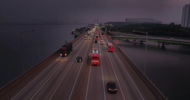 Cars crossing a bridge over the sea at sunset