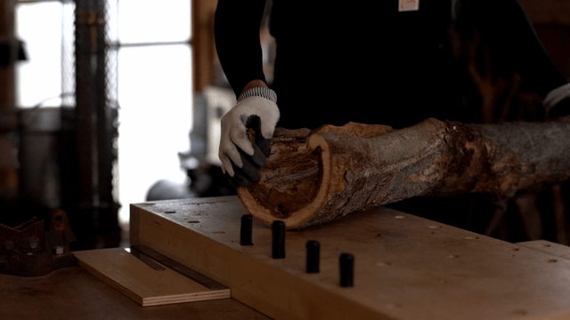 Carpenter handling a log in workshop