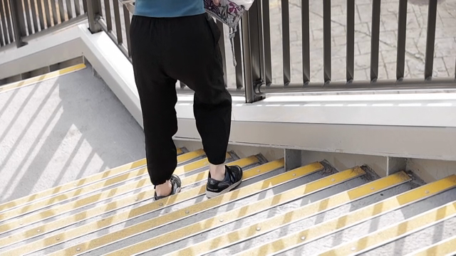 A person struggling down outdoor stairs