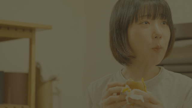 Young woman enjoying a burger indoors