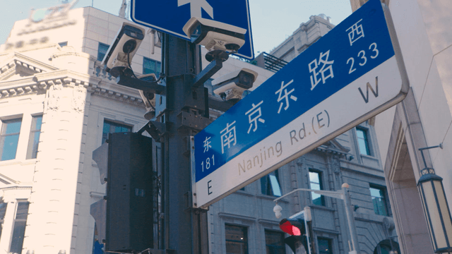 Street sign and surveillance camera in a Chinese city
