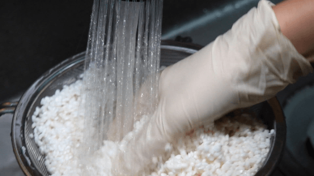 Rinsing rice under running water