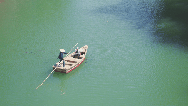 Two people on a boat in a green lake