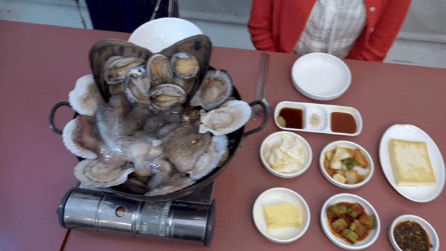 Chicken and seafood soup with side dishes on the table