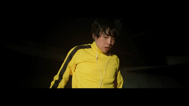 Man wearing a yellow tracksuit with earphones