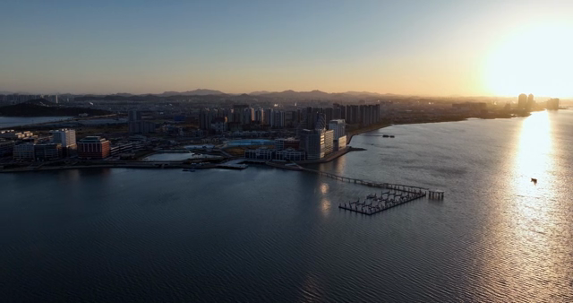 A city skyline with a setting sun