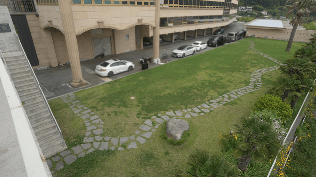 Building with a green lawn and parked cars