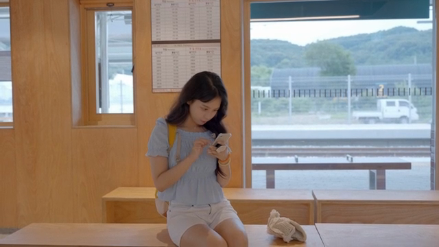 A woman using her phone at a train station