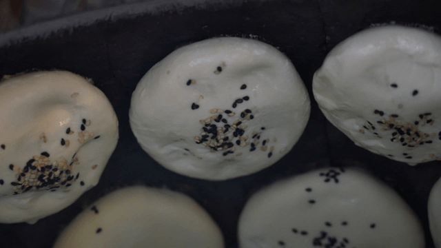Fire oven dumplings topped with sesame seeds neatly placed in an oven