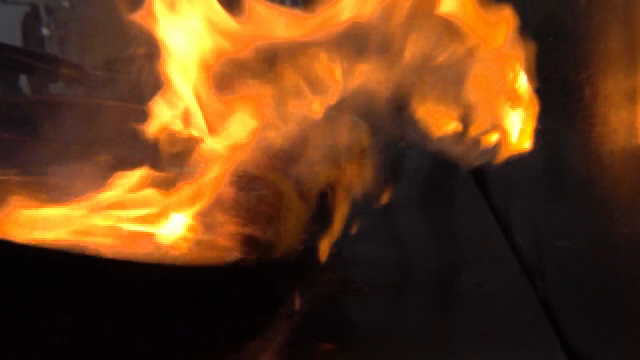 Flames rising from a pan in a kitchen