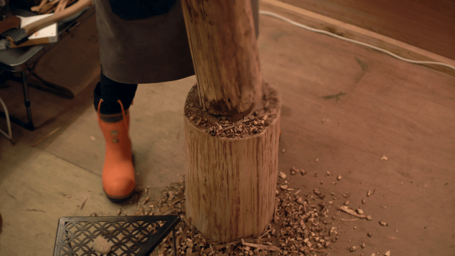 Person carving wood indoors