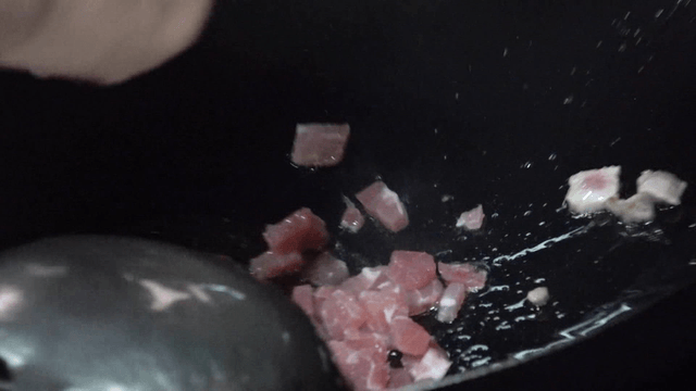 Diced meat added into wok in kitchen