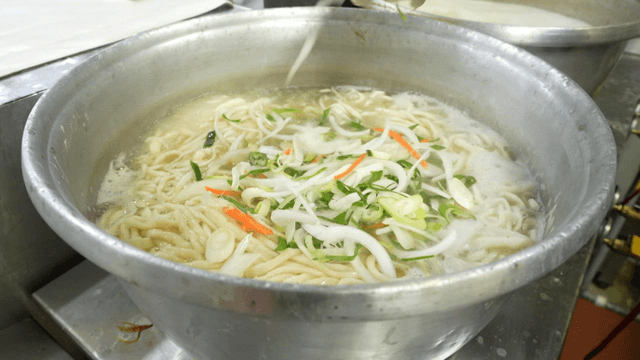 Noodles boiling with fresh vegetables