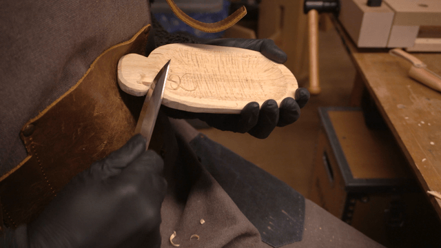 Woodcraft artisan carving wood on workbench