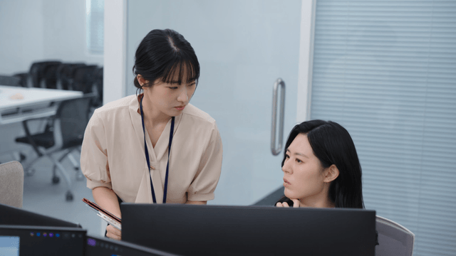 Two colleagues discussing work at a desk