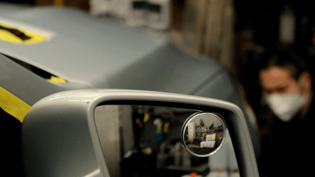 Car side mirror in a workshop setting