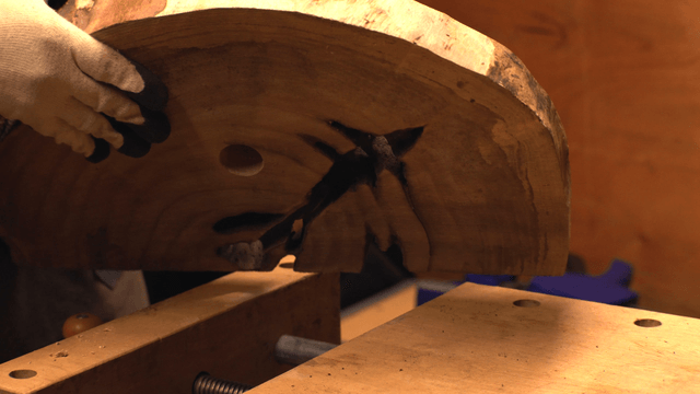 Wooden slab being inspected in workshop