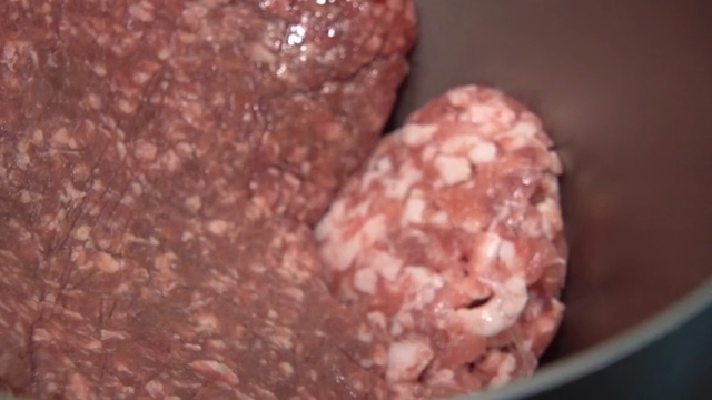 Ground meat being mixed in a bowl