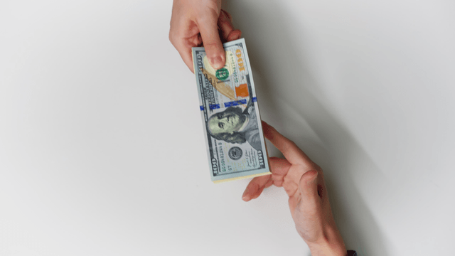 Hands exchanging Korean and US currency
