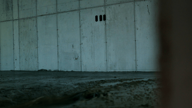 Worker smoothing concrete floor indoors