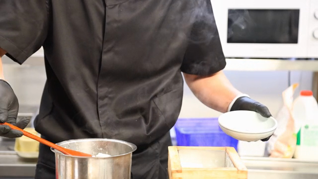 Chef preparing tofu in a kitchen