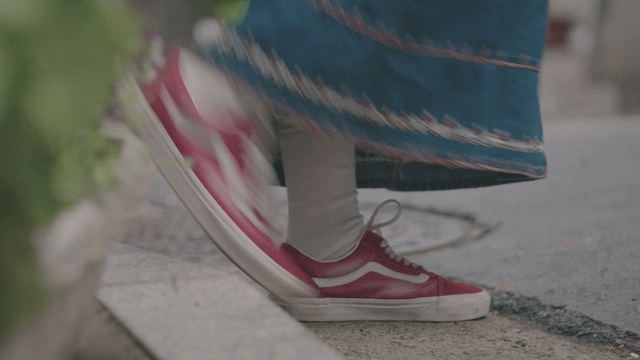 Person wearing red sneakers on a sidewalk