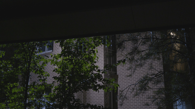 Raindrops falling from eaves in front of brick house