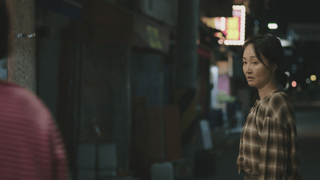 Mother and daughter talking on a dark street
