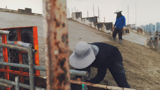 Workers smoothing concrete on a slope