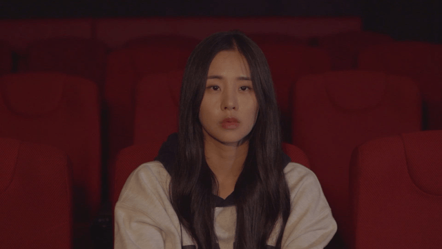 Woman sitting in a theater seat, absorbed in the experience